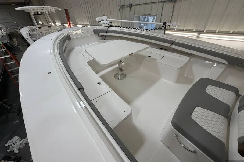 White Yacht Photos Pics 2024 Regulator 34 boat interior with seating and table in a showroom.