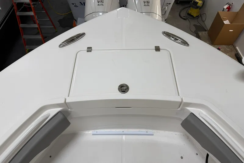 White Yacht Photos Pics 2024 Regulator 34 boat deck with storage compartment and V6 engine in background.