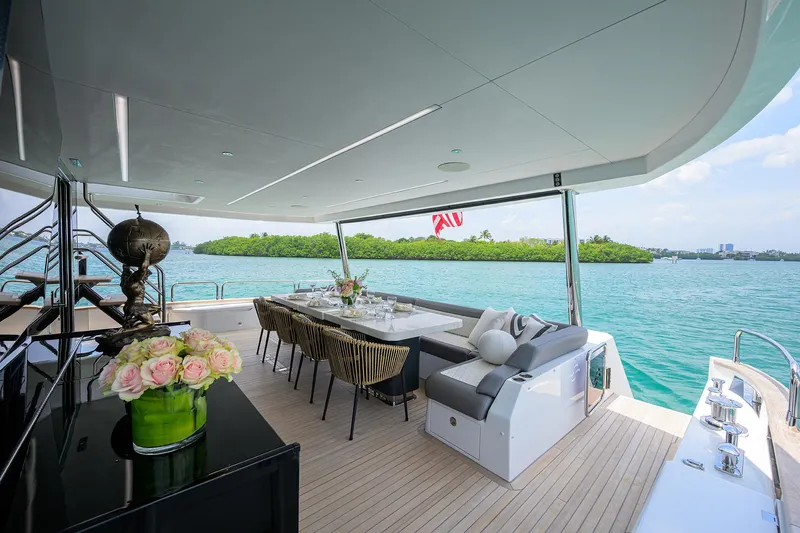  Yacht Photos Pics Luxurious 2024 Sirena 88 yacht deck with elegant dining area and scenic ocean view.