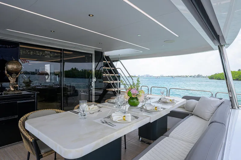  Yacht Photos Pics Luxurious 2024 Sirena 88 yacht deck with elegant dining setup and scenic ocean view.