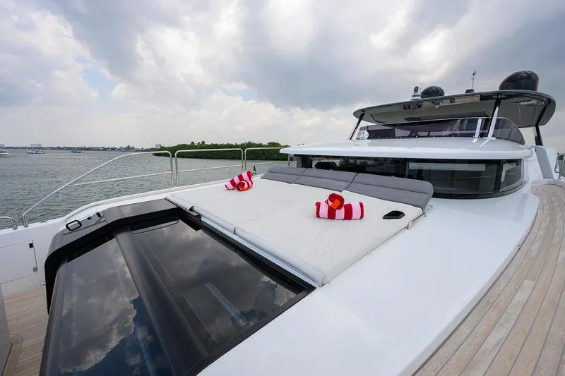  Yacht Photos Pics 2024 Sirena 88 yacht with sunbathing deck, striped towels, and scenic ocean view.