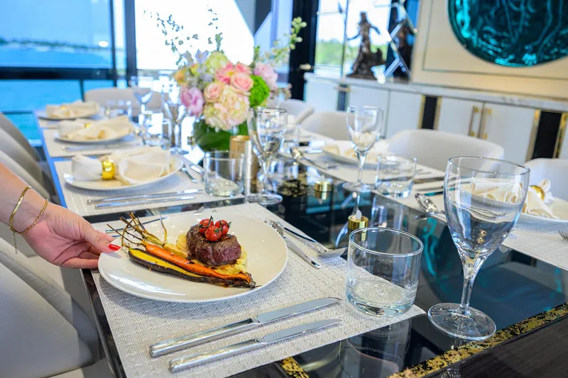  Yacht Photos Pics Luxurious dining setup on Sirena 88 yacht, featuring gourmet dish and elegant tableware, 2024 model.