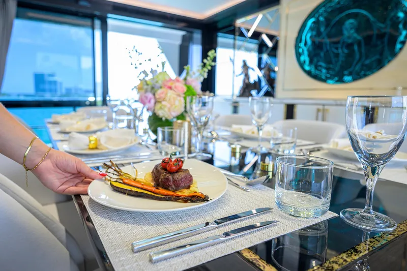  Yacht Photos Pics Luxurious dining setup on 2024 Sirena 88 yacht, featuring gourmet meal and elegant tableware.