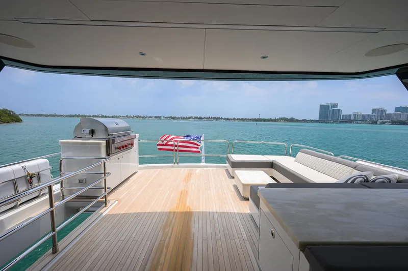  Yacht Photos Pics Luxury deck view on 2024 Sirena 88 yacht, featuring seating and grill, overlooking serene waters.