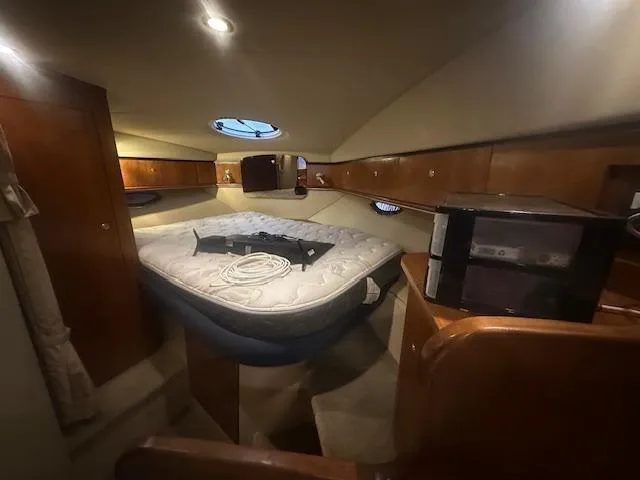  Yacht Photos Pics 2005 Cruisers Yachts 340 Express cabin interior with bed and wooden cabinetry.