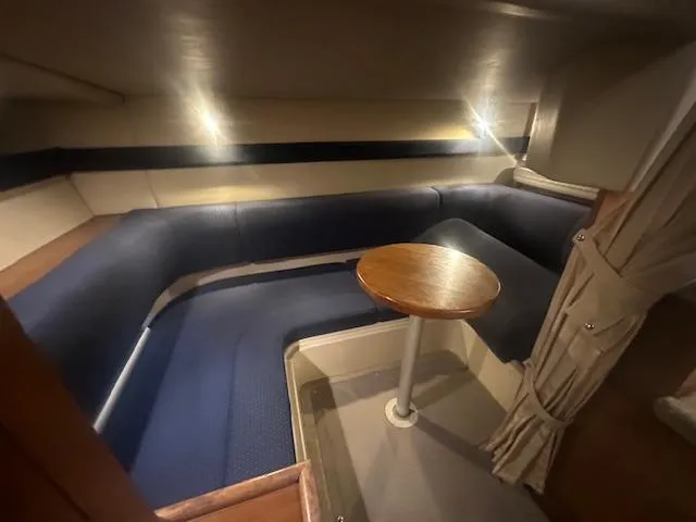  Yacht Photos Pics 2005 Cruisers Yachts 340 Express interior with blue seating and wooden table.