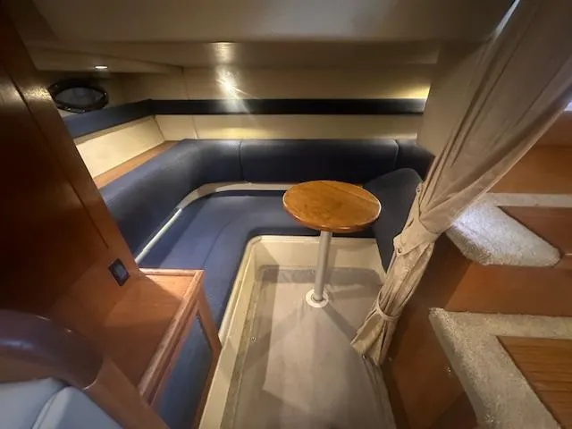 Yacht Photos Pics 2005 Cruisers Yachts 340 Express interior with blue seating and wooden table.