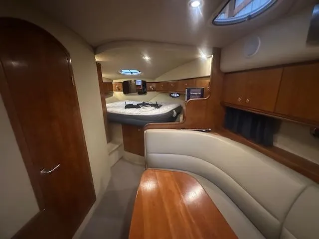  Yacht Photos Pics 2005 Cruisers Yachts 340 Express cabin interior with wood finish and cozy seating area.
