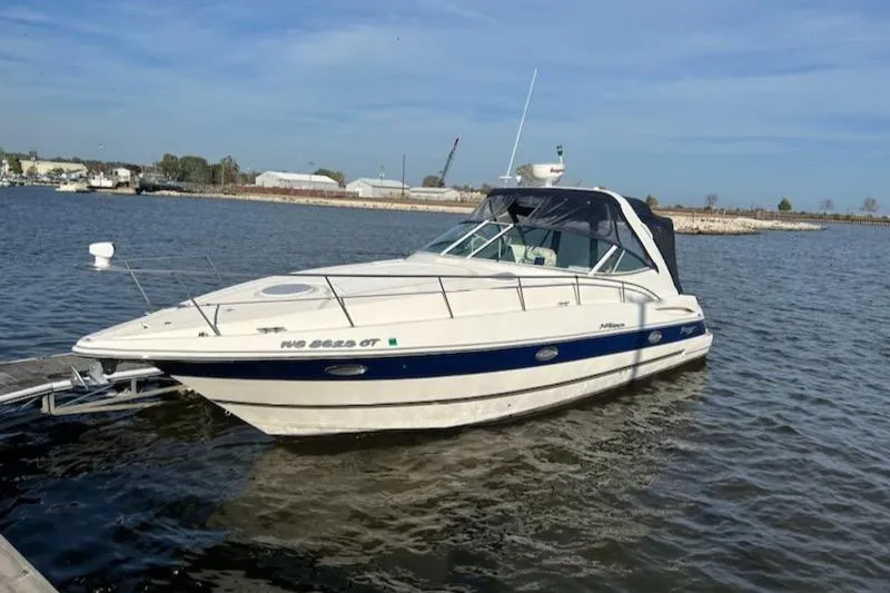  Yacht Photos Pics 2005 Cruisers Yachts 340 Express boat docked on calm water.