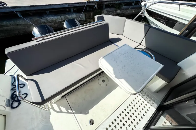  Yacht Photos Pics 2023 Beneteau Antares 11 boat deck with seating and table, docked at marina.