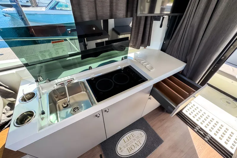  Yacht Photos Pics Modern kitchen area in 2023 Beneteau Antares 11 boat with sink and stove.