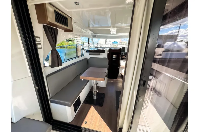  Yacht Photos Pics Interior of 2023 Beneteau Antares 11, featuring modern seating and dining area.