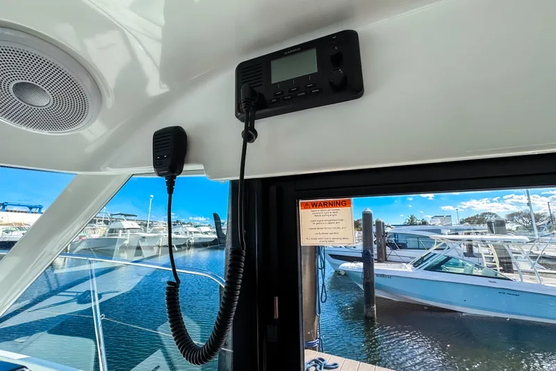  Yacht Photos Pics Interior view of 2023 Beneteau Antares 11 with marine radio and docked boats.