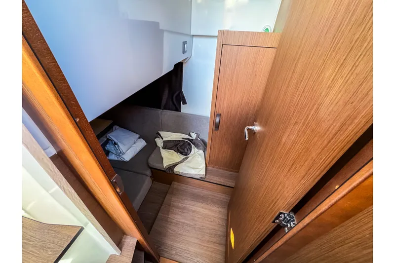  Yacht Photos Pics 2023 Beneteau Antares 11 cabin interior with wooden finish and cozy seating area.