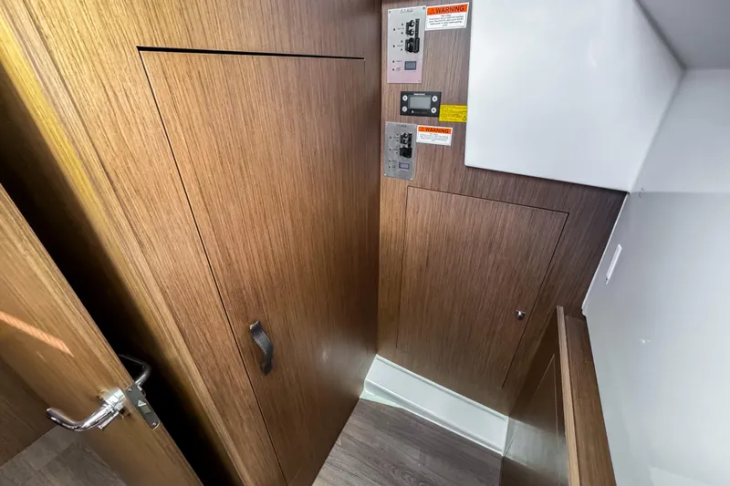  Yacht Photos Pics 2023 Beneteau Antares 11 interior with wooden paneling and control panels.