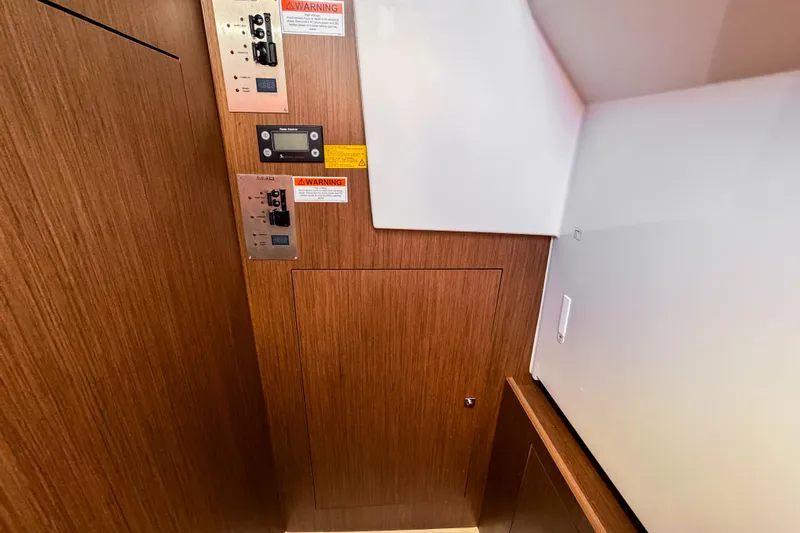  Yacht Photos Pics Control panel area in 2023 Beneteau Antares 11 with wood finish and warning labels.