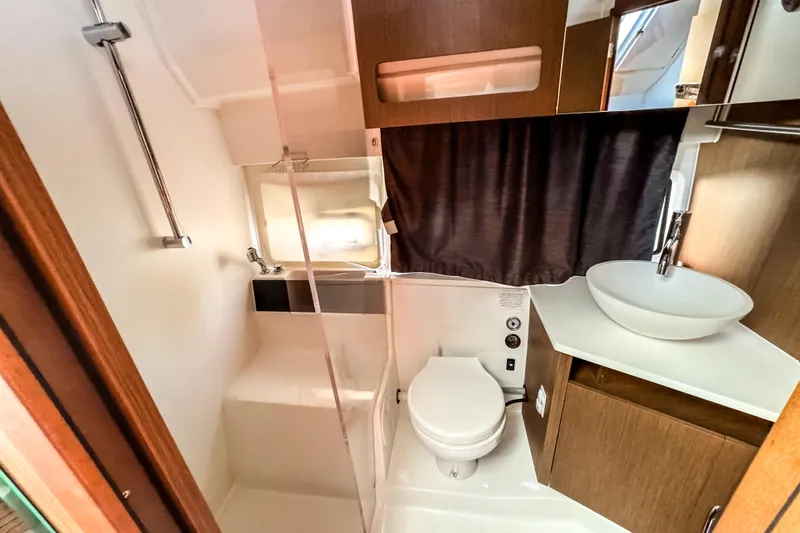  Yacht Photos Pics 2023 Beneteau Antares 11 bathroom with modern fixtures and wooden cabinetry.