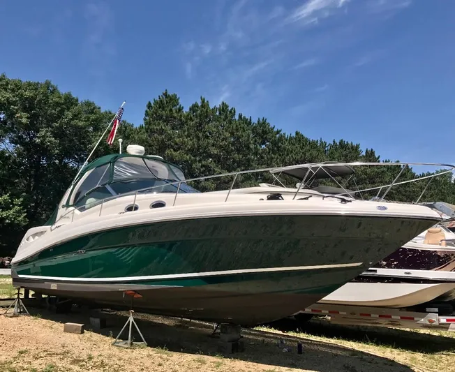 Serenity Yacht Photos Pics 2004 Sea Ray 340 Sundancer boat on land, green and white, under clear blue sky.