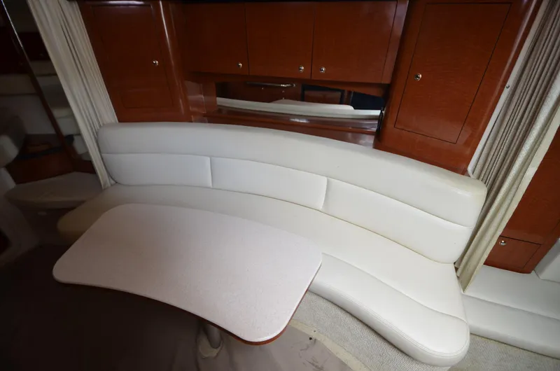 Serenity Yacht Photos Pics Interior of 2004 Sea Ray 340 Sundancer with white seating and wooden cabinetry.