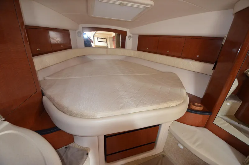 Serenity Yacht Photos Pics 2004 Sea Ray 340 Sundancer cabin interior with bed and wooden cabinetry.
