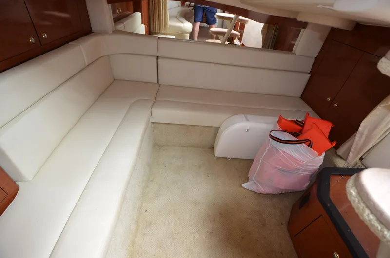 Serenity Yacht Photos Pics Interior of 2004 Sea Ray 340 Sundancer with white seating and wooden cabinetry.
