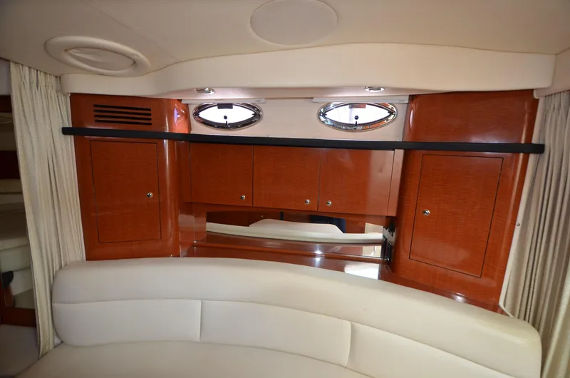 Serenity Yacht Photos Pics Interior of 2004 Sea Ray 340 Sundancer with wood cabinets and porthole windows.