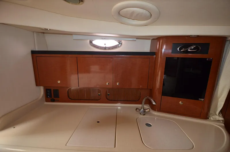 Serenity Yacht Photos Pics 2004 Sea Ray 340 Sundancer interior kitchen with wooden cabinets and sink.