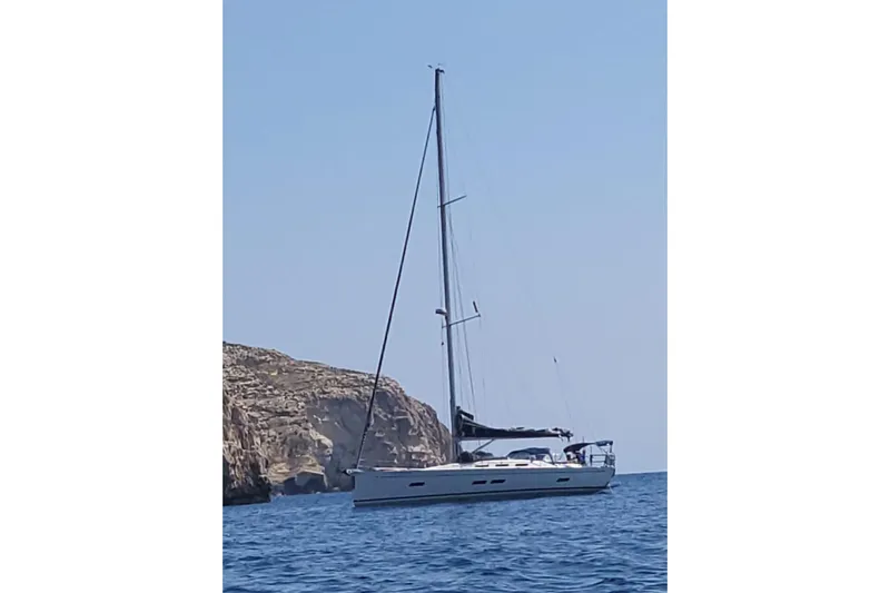 Deiopea Yacht Photos Pics Italia Yachts IY13.98 2013 sailboat on calm sea near rocky coastline.