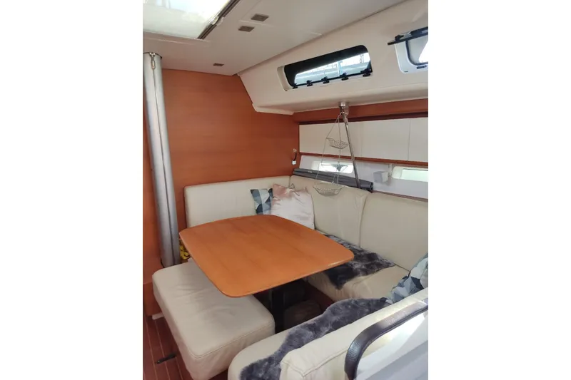 Deiopea Yacht Photos Pics Interior of 2013 Italia Yachts IY13.98, featuring a cozy dining area with wooden table.