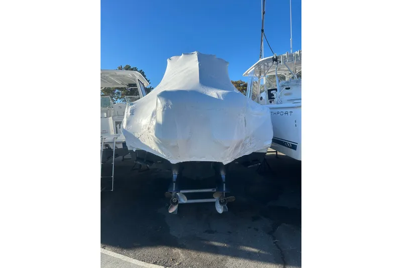  Yacht Photos Pics Covered 2015 Sailfish 290 CC boat on trailer, parked outdoors.