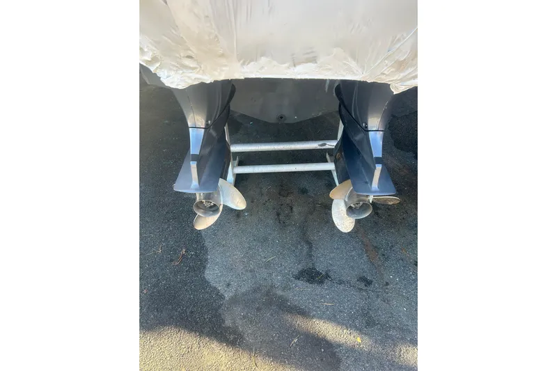  Yacht Photos Pics Twin outboard motors on a 2015 Sailfish 290 CC boat, parked on asphalt.