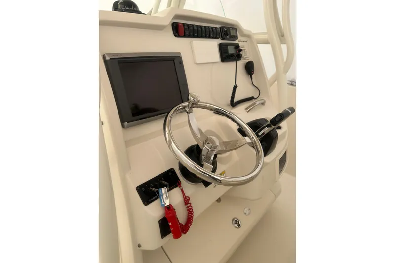  Yacht Photos Pics Control panel of 2015 Sailfish 290 CC boat with steering wheel and navigation equipment.