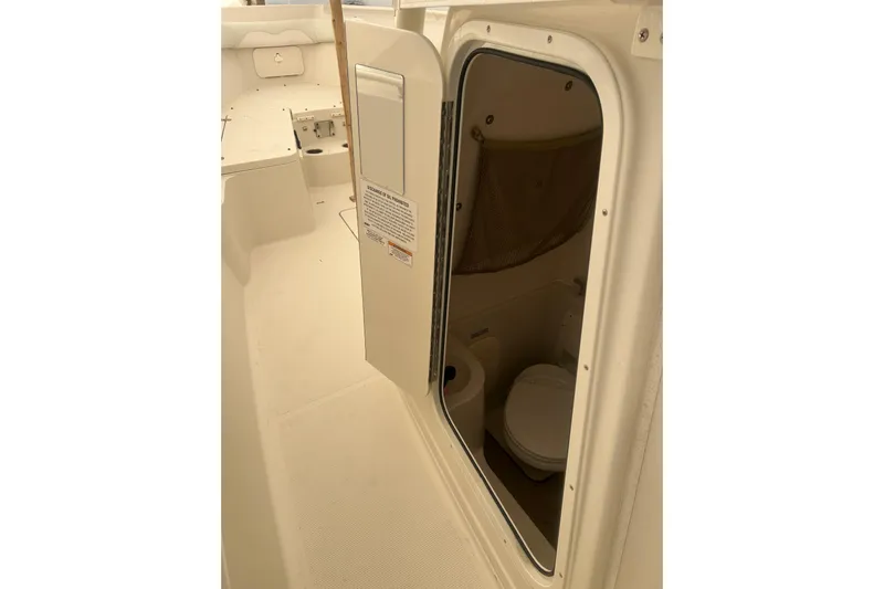  Yacht Photos Pics 2015 Sailfish 290 CC boat interior with open door revealing compact restroom.