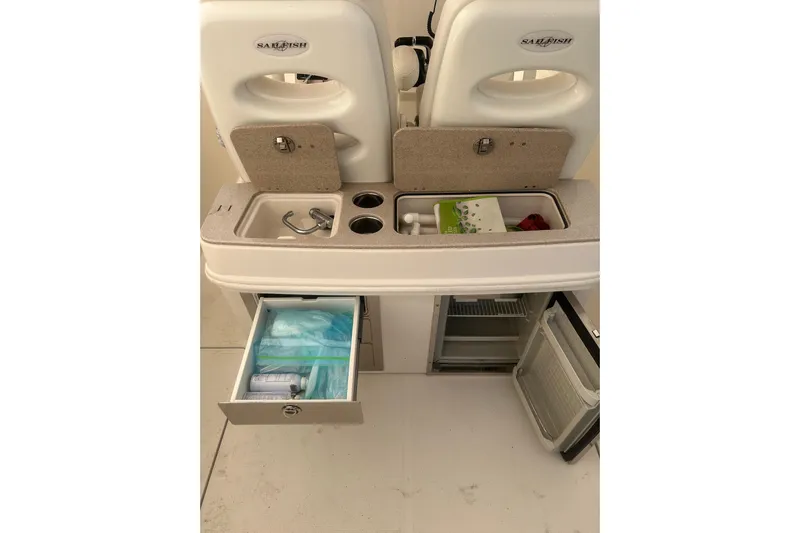  Yacht Photos Pics 2015 Sailfish 290 CC boat interior with storage compartments and mini fridge.