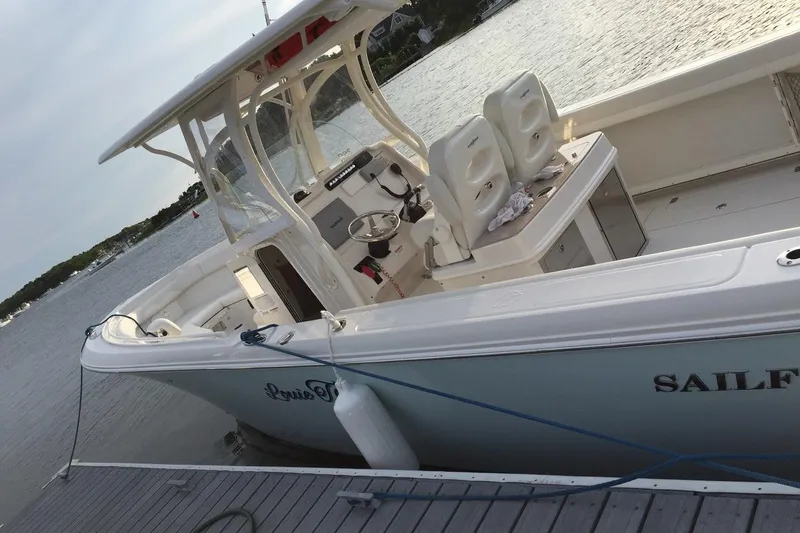  Yacht Photos Pics 2015 Sailfish 290 CC boat docked by the water on a sunny day.