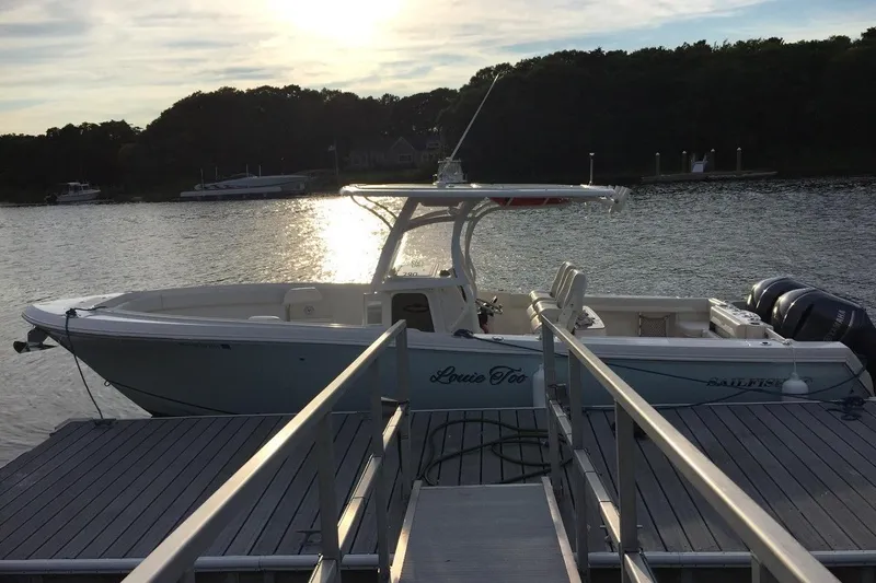  Yacht Photos Pics 2015 Sailfish 290 CC boat docked at sunset on a calm lake.