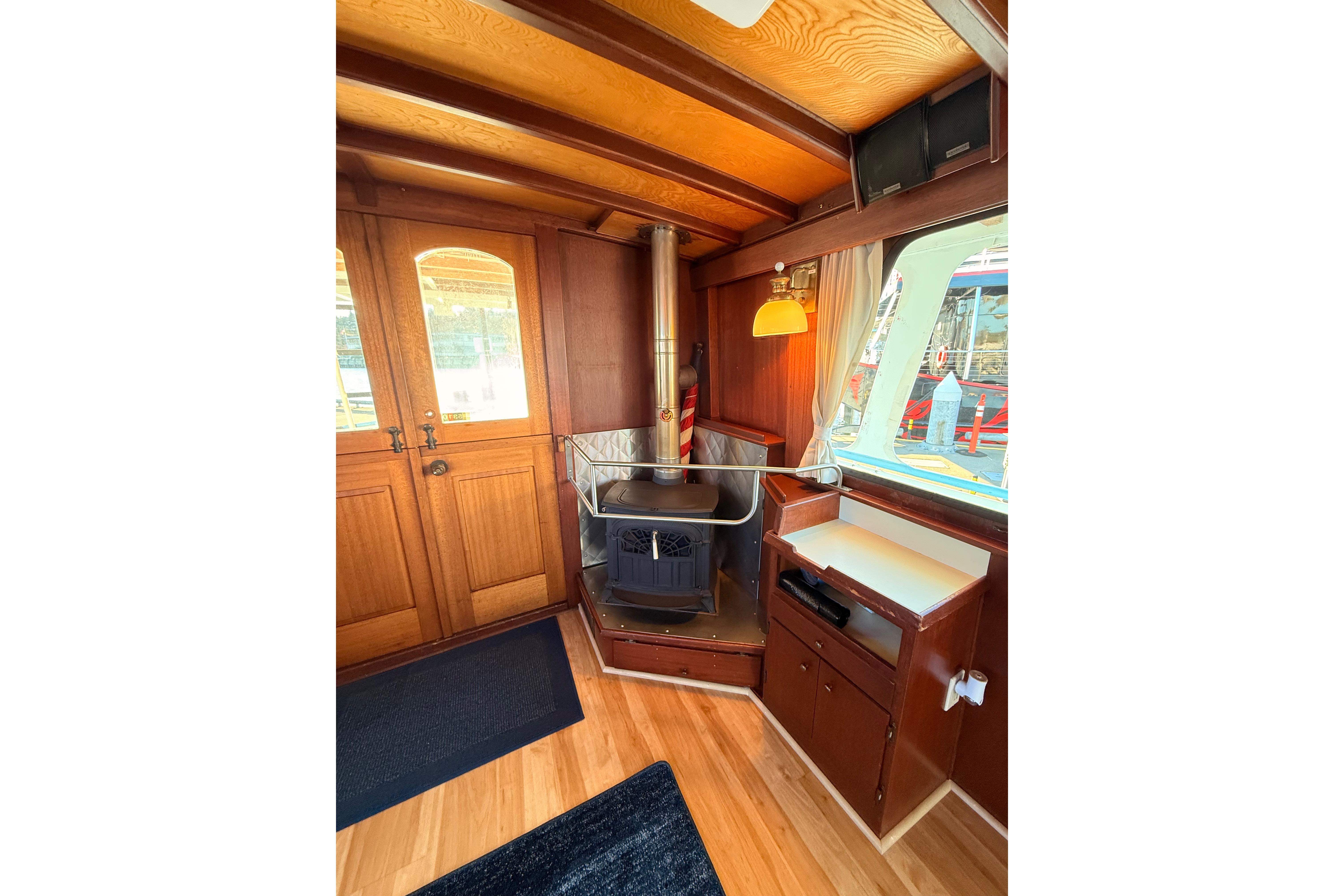 Interior of a 1965 custom trawler with wood paneling and a cozy stove.