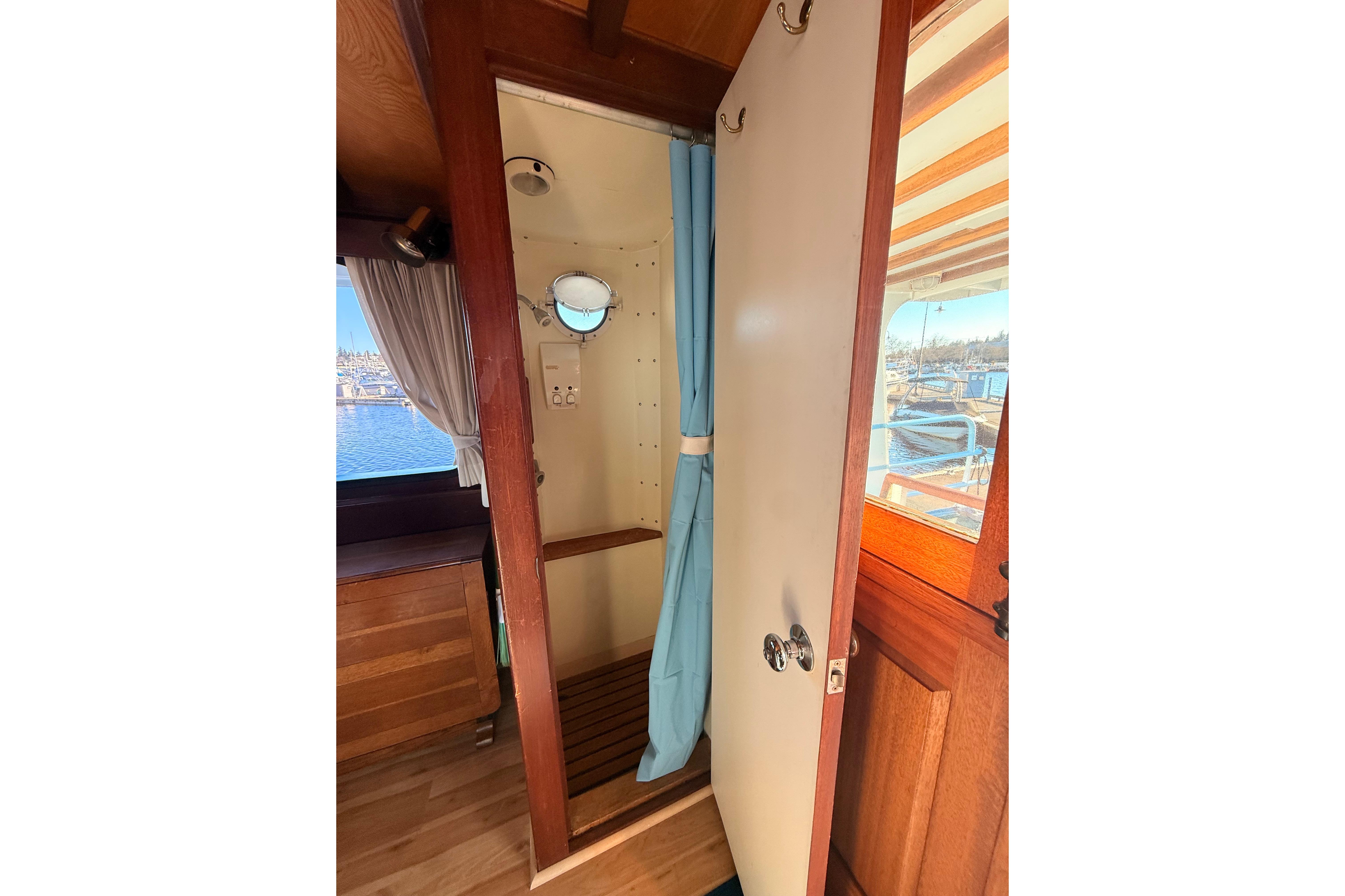 Interior of a 1965 Custom Trawler with wooden accents and a small porthole window.