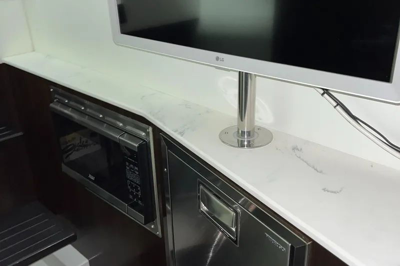  Yacht Photos Pics 2023 Cruisers Yachts 38 GLS interior with TV, microwave, and stainless steel appliances.