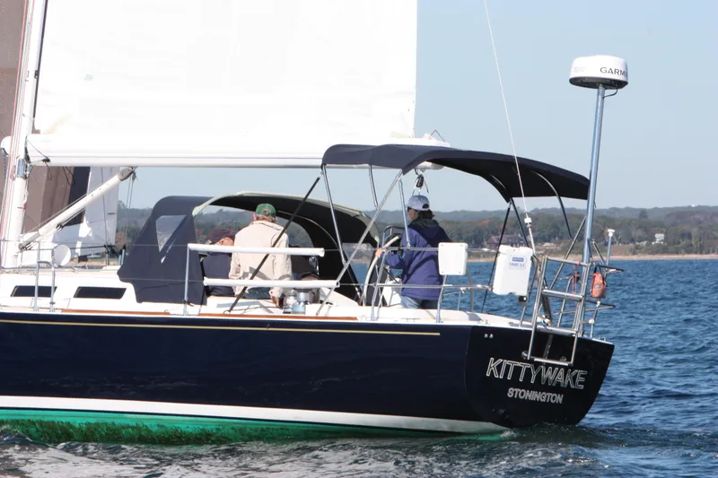 Kittywake Yacht Photos Pics Sailing yacht J/42 from 1996 on the water, featuring a dark hull and crew onboard.