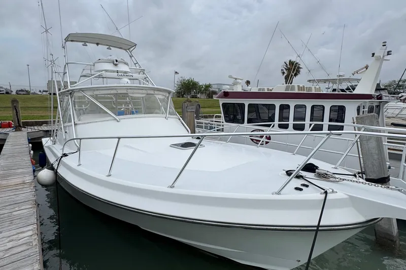 Pandemonium Yacht Photos Pics 2000 Liberty 42 Express boat docked at marina under cloudy sky.