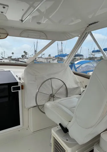 Pandemonium Yacht Photos Pics Interior of 2000 Liberty 42 Express yacht with steering wheel and white seating.