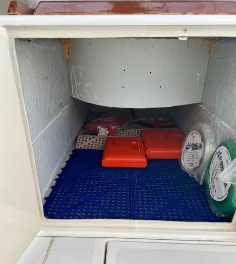 Pandemonium Yacht Photos Pics Storage compartment in a 2000 Liberty 42 Express boat with safety equipment.