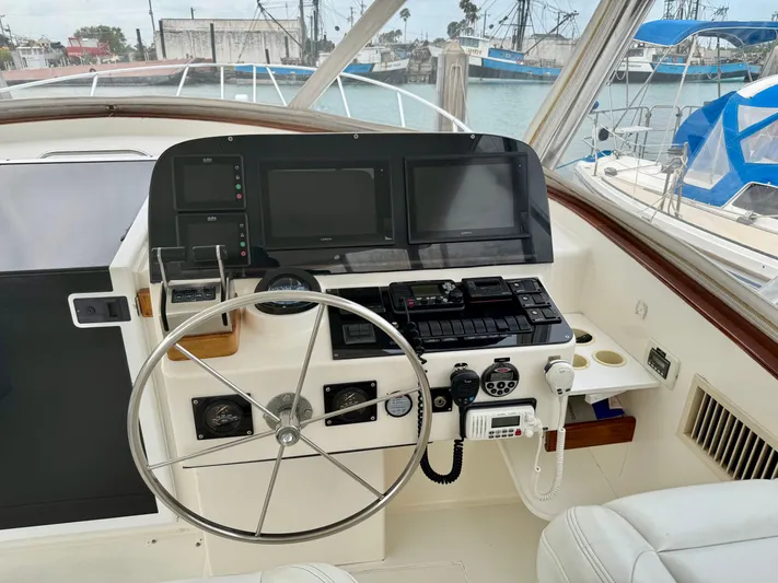 Pandemonium Yacht Photos Pics Helm of 2000 Liberty 42 Express yacht with steering wheel and navigation equipment.
