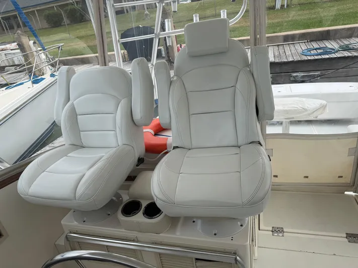 Pandemonium Yacht Photos Pics Luxury seating on a 2000 Liberty 42 Express boat, featuring plush white captain chairs.