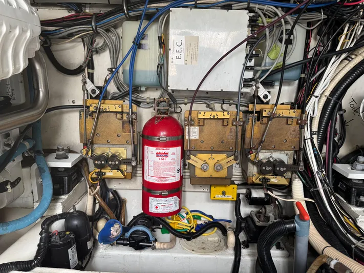 Pandemonium Yacht Photos Pics Engine room of 2000 Liberty 42 Express with wiring, fire extinguisher, and control panels.