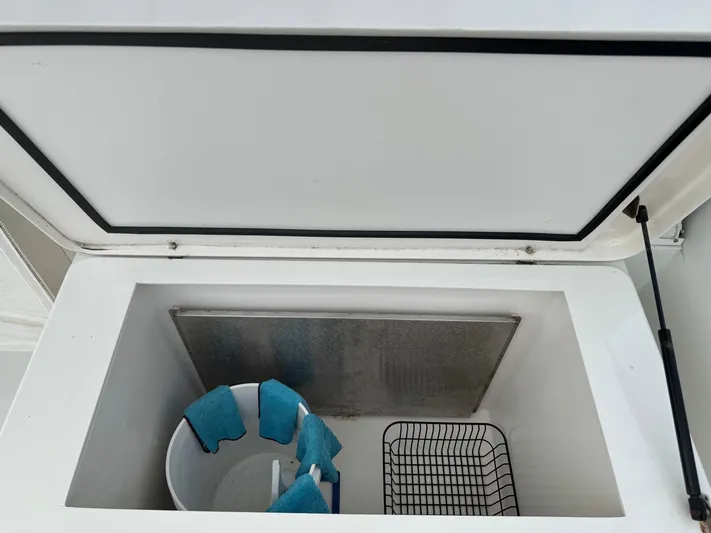 Pandemonium Yacht Photos Pics Open storage compartment on 2000 Liberty 42 Express boat with bucket and wire basket.