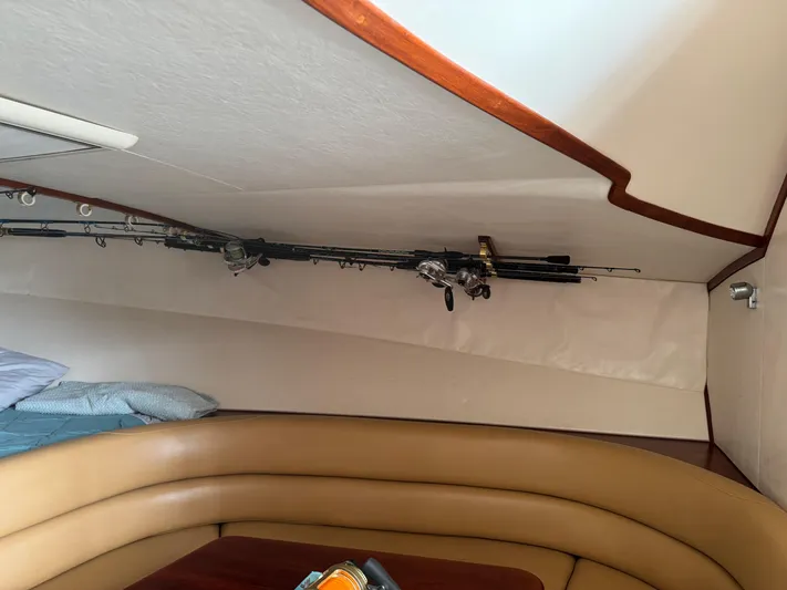 Pandemonium Yacht Photos Pics Interior of 2000 Liberty 42 Express boat with fishing rods and seating area.