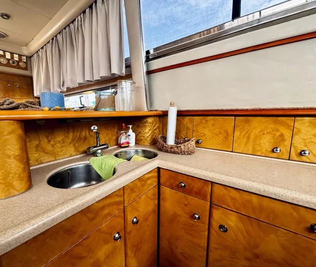  Yacht Photos Pics Luxurious 1994 Princess 45 Flybridge yacht kitchen with wood cabinetry and dual sinks.