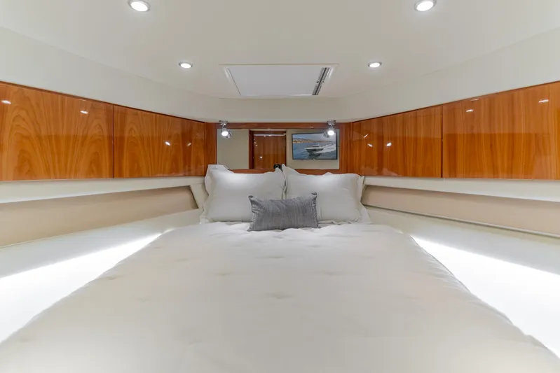No Contingencies Yacht Photos Pics Luxurious bedroom interior of 2012 Riviera 44 Sport Yacht with wood paneling and cozy bedding.